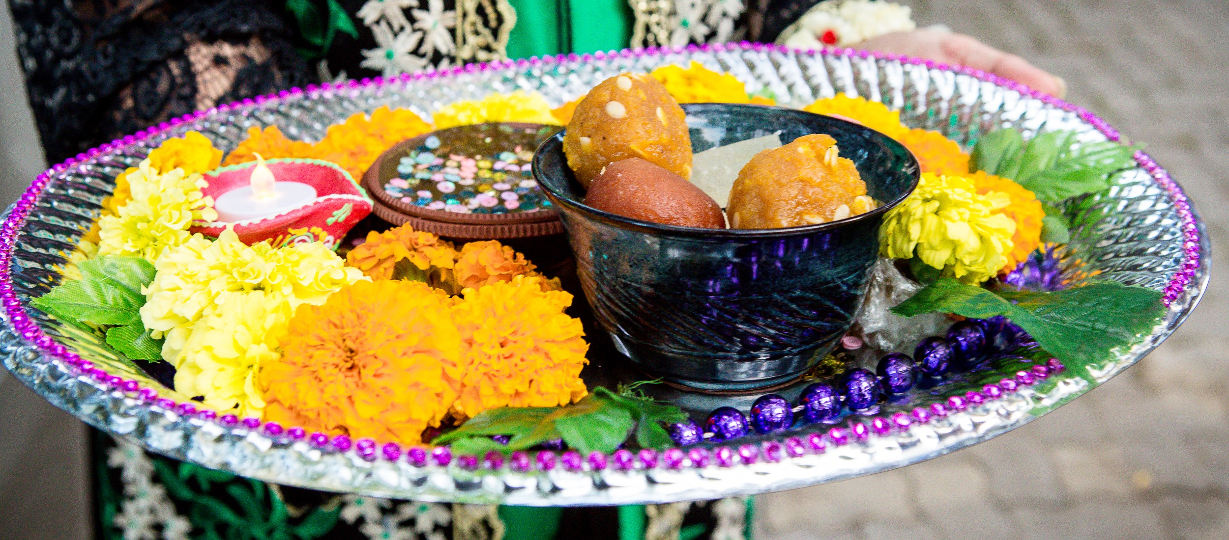Traditional wedding offering tray with flowers, sweets, and ceremonial decorations